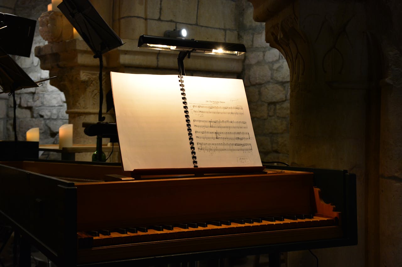 services-01 An evocative scene with sheet music lit on a harpsichord in a dimly lit stone interior, evoking a classical music ambiance.