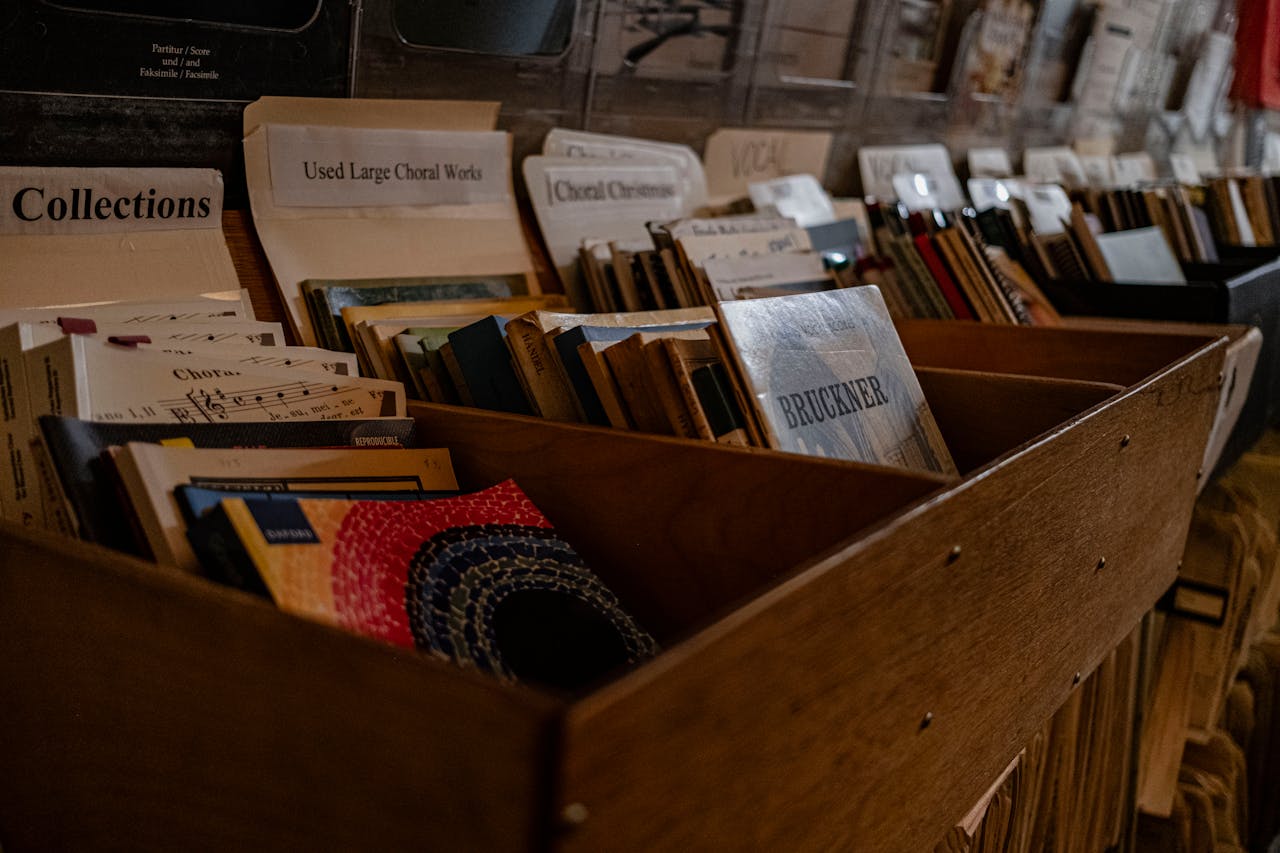 services-img Close-up view of assorted sheet music stored in a wooden file drawer in a music store.
