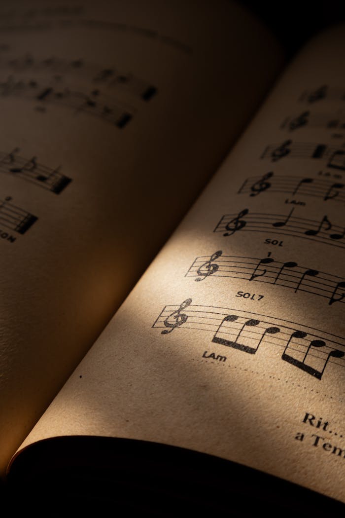 services-03 A detailed view of a vintage music sheet, illuminated by warm light, conveying a sense of history and art.