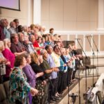 A diverse choir performing in a modern church setting, showcasing unity and harmony.